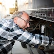 older driver inspecting a trailer